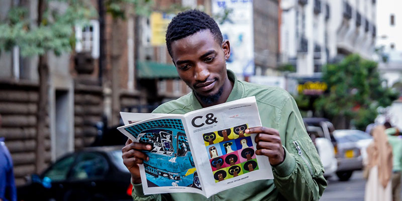A person standing in the street reading C& magazine